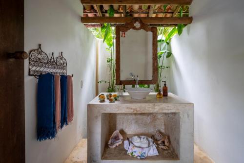 a bathroom with a sink and a mirror at Pousada Hibisco in Trancoso