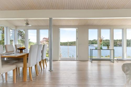 a dining room with a table and chairs and a view of the water at Spectacular lake plot, Stockholm archipelago in Dalarö