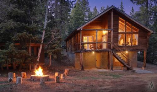 a log cabin with a fire in front of it at Rustic Mountain Log Cabin with Fire Pit in Duck Creek Village