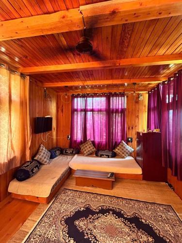 a bedroom with two beds in a room with purple curtains at Cedar Forest BnB Villa in Kasol