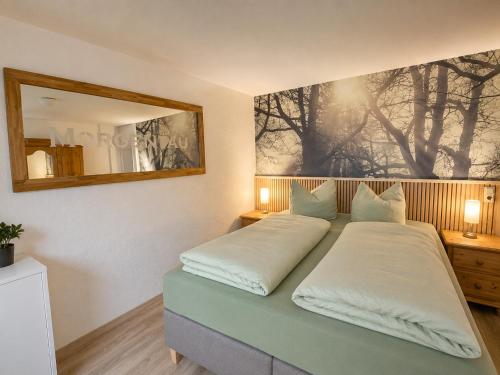 a bedroom with two beds and a mirror on the wall at Ferienwohnungen an der alten Stadtmauer in Blankenburg