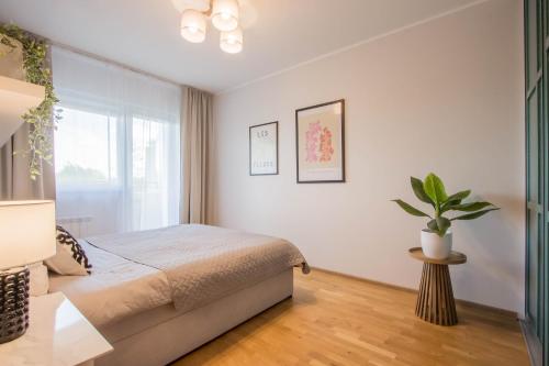 a bedroom with a bed and a potted plant at Aardla Cozy Apartment in Tartu