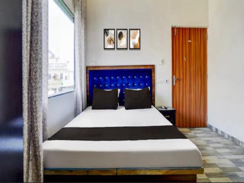 a bedroom with a large bed with a blue headboard at Hotel Pilgrrim in Varanasi