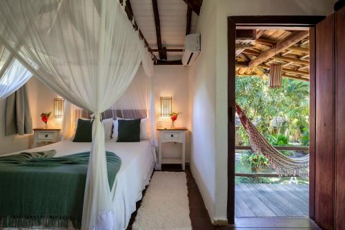 a bedroom with a bed with a canopy at Pousada Hibisco in Trancoso
