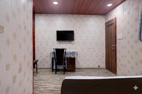 a room with a tv and a table and a chair at Hotel Garden Lodging And Boarding in Ulhāsnagar