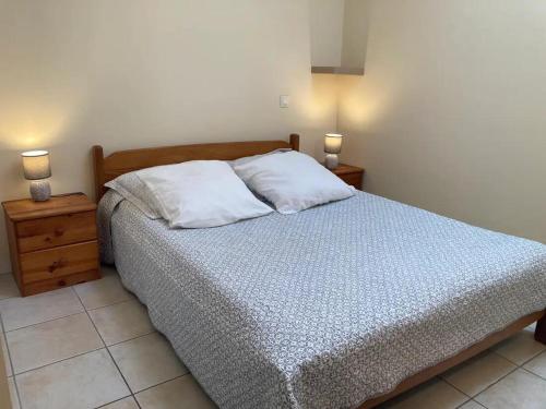 a bedroom with a bed with two night stands and two lamps at Tucaut in Toulouse