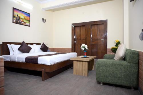 a hotel room with a bed and a chair at Hotel King By Panch Aarohan in Pithorāgarh