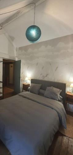 a bedroom with a large bed with a blue light at Le Figuier , Domaine La Capitainerie in Bazoges-en-Pareds