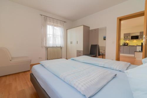 a bedroom with two beds and a chair in it at Stompferhof Erkerwohnung in Caldaro