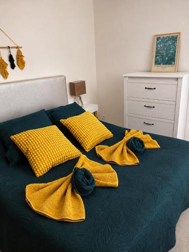 a bed with yellow blankets and yellow pillows on it at Gîte Le Jasmin in Le Thor