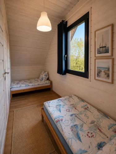 a small room with a bed and a window at Morze Lubiatowo in Lubiatowo