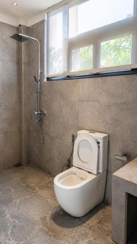 a bathroom with a toilet with a window and a shower at Ella Claython Hills in Ella
