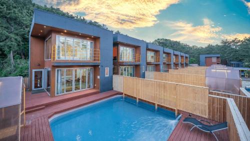 a house with a swimming pool on a deck at Uljin 207 Mile Pool Villa in Uljin
