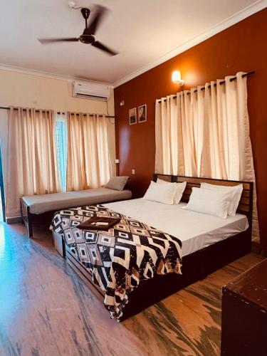 a bedroom with two beds and a ceiling at hello varkala beach view balcony resort in Varkala