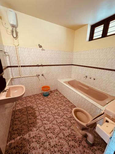 a bathroom with a tub and a toilet and a sink at hello varkala beach view balcony resort in Varkala