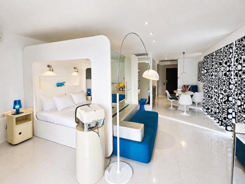ein weißes Schlafzimmer mit einem blau-weißen Bett in der Unterkunft Chill Hotel Seminyak in Seminyak