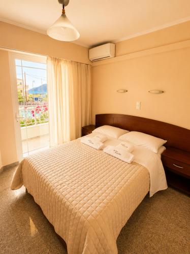 a bedroom with a bed with a large window at Kalias Hotel in Vasiliki