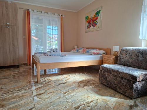 a bedroom with a bed and a chair and a window at San Lorenzo in Lopar