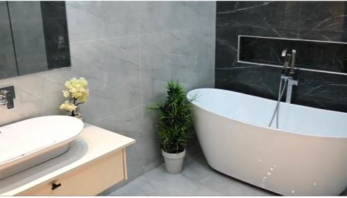a bathroom with a white bath tub and a sink at Meria town attock in Attock