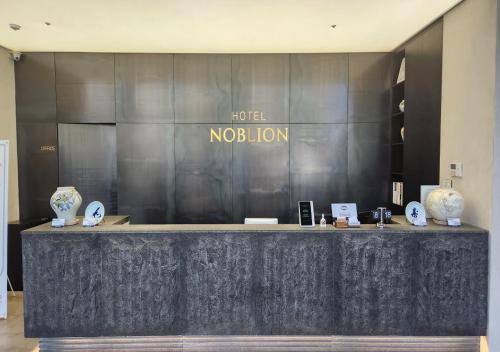 a lobby with a counter with vases on it at Pohang Hotel Noblion in Pohang