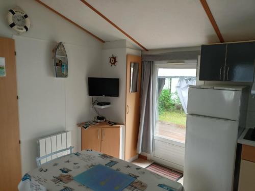 a small kitchen with a refrigerator and a window at Thery location 17 in Saint-Pierre-dʼOléron