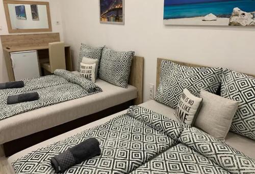 a living room with two beds and a couch at Downtown Cosy-Rooms in Miskolc