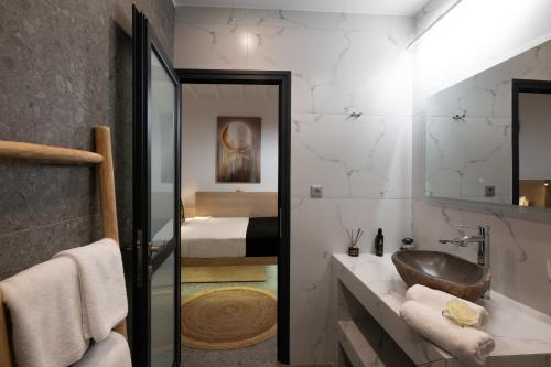 a bathroom with a sink and a bedroom at Double Mini Suites Adults Only in Ano Mera