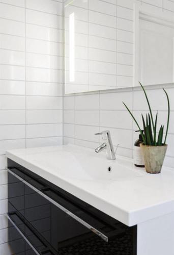 a white bathroom with a sink and a mirror at Apartment close to city center in Haugesund