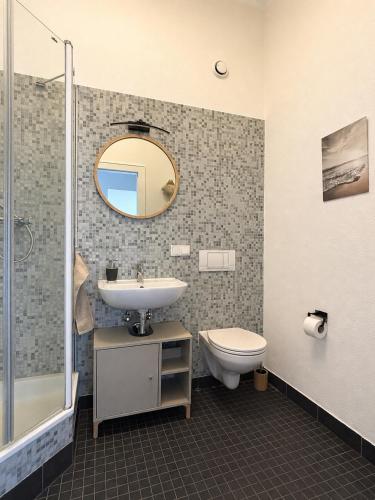 ein Badezimmer mit Waschbecken, Toilette und Spiegel in der Unterkunft Apartment Boho in Cottbus