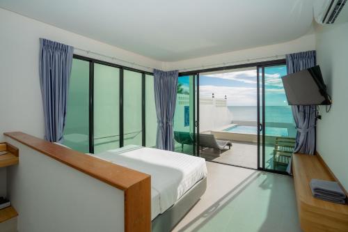 a bedroom with a bed and a view of the ocean at เจ้าหลาว ซี บรีส รีสอร์ท in Ban Mu Dut