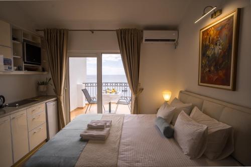 a bedroom with a bed with a view of a balcony at Villa Milan in Sveti Stefan