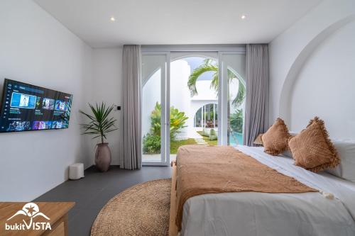 a bedroom with a large bed and a tv at Villa Luminosa 3 by Bukit Vista in Uluwatu