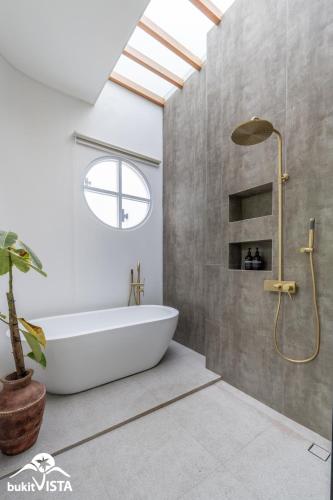 a bathroom with a white tub and a window at Villa Luminosa 3 by Bukit Vista in Uluwatu