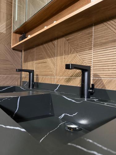 a sink with two faucets in a bathroom at Berg en Bos Suite met luxe jacuzzi in Apeldoorn