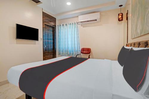 a hotel room with a bed and a television at Super Collection O Halcyon SS Grand in Hyderabad