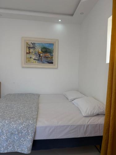 a bed in a bedroom with a painting on the wall at Vengo Apartments in Kotor