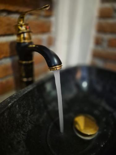 a sink with water coming out of a faucet at pesisircottage & stay in Selong Belanak