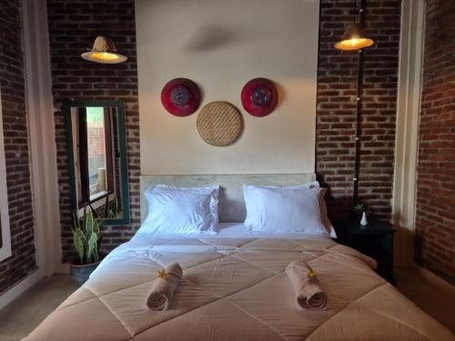 a bedroom with a large bed with two shoes on it at pesisircottage & stay in Selong Belanak
