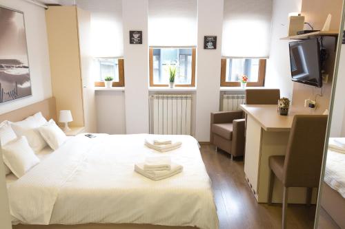 Habitación con cama, escritorio y ordenador. en Grand Central Accommodation - Smardan, en Bucarest