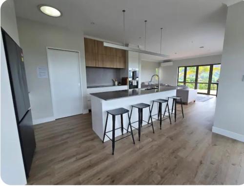 a kitchen with a counter and bar stools at Casa Del Sol in Riwaka