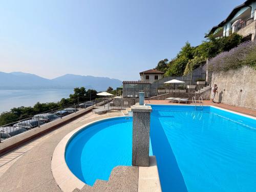 a blue swimming pool with a view of the water at Lakeview Residence in Oggebbio