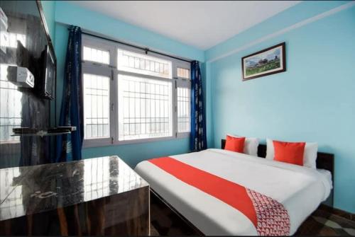 a bedroom with a bed with blue walls and a window at THE PINE STAy in Chail