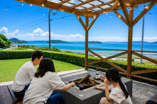 a group of people sitting at a table eating food at Seaside Villa KAMANO in Aji