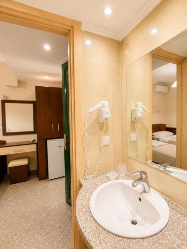 a bathroom with a sink and a mirror at Kalias Hotel in Vasiliki