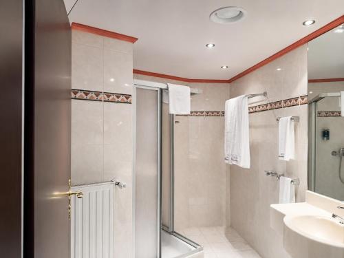 a bathroom with a shower and a sink at Ambassador Hotel Eupen in Eupen