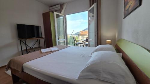 a bedroom with a bed with a view of a balcony at Luna di mare 2 Igalo in Igalo