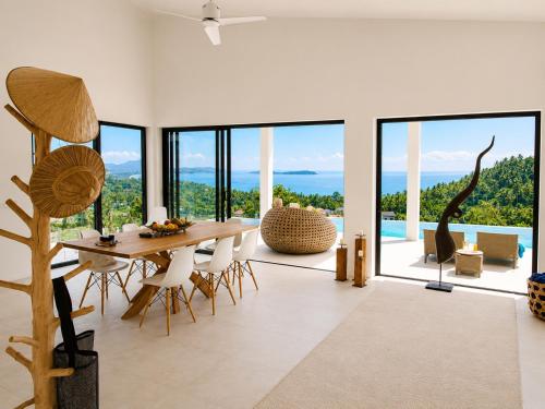 a dining room with a table and views of the ocean at INDIGO VILLA Samui in Koh Samui