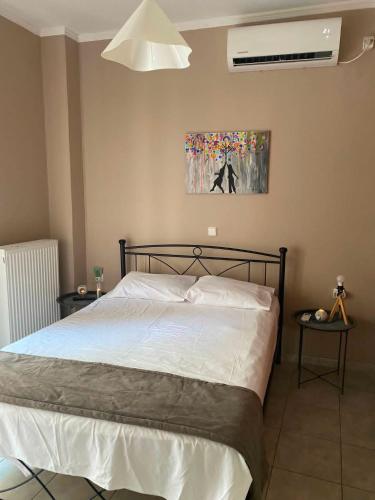 a bedroom with a white bed and a picture on the wall at Calypso Rooms in Preveza