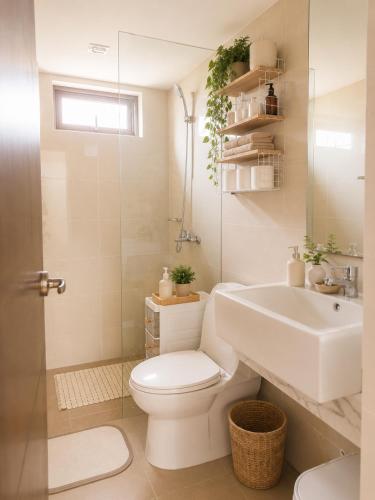 a white bathroom with a toilet and a sink at Elegant 1BR Unit at Bryant Parklane, Capital Town near Malls and Tourist Destinations in Pampanga, Free Pool Access, Netflix, Prime Video in San Fernando