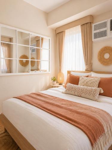 a large bed in a bedroom with a window at Elegant 1BR Unit at Bryant Parklane, Capital Town near Malls and Tourist Destinations in Pampanga, Free Pool Access, Netflix, Prime Video in San Fernando